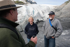 Kenai Fjords ranger and happy visitors in front of a glacier